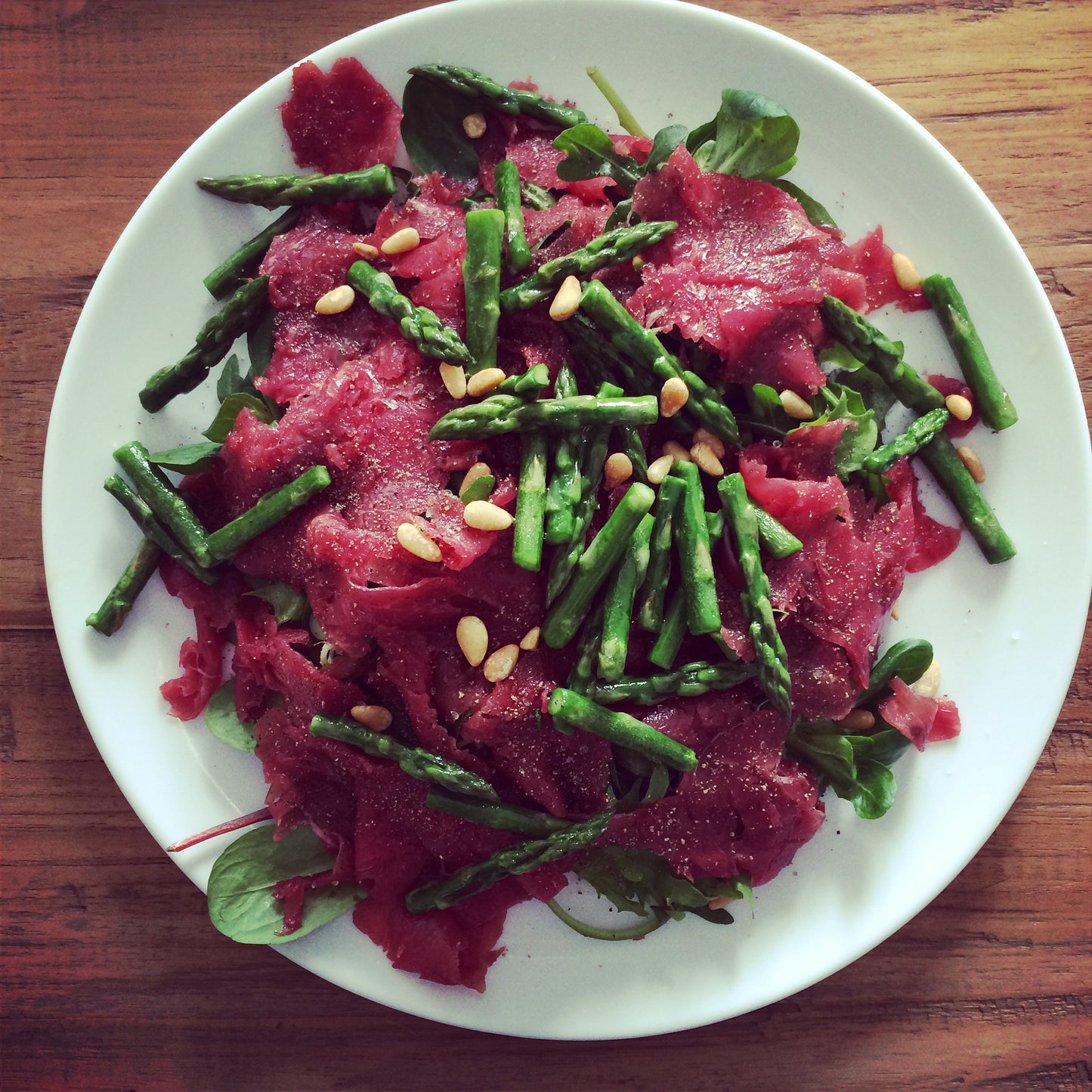 Rundercarpaccio met groene asperges en pijnboompitten