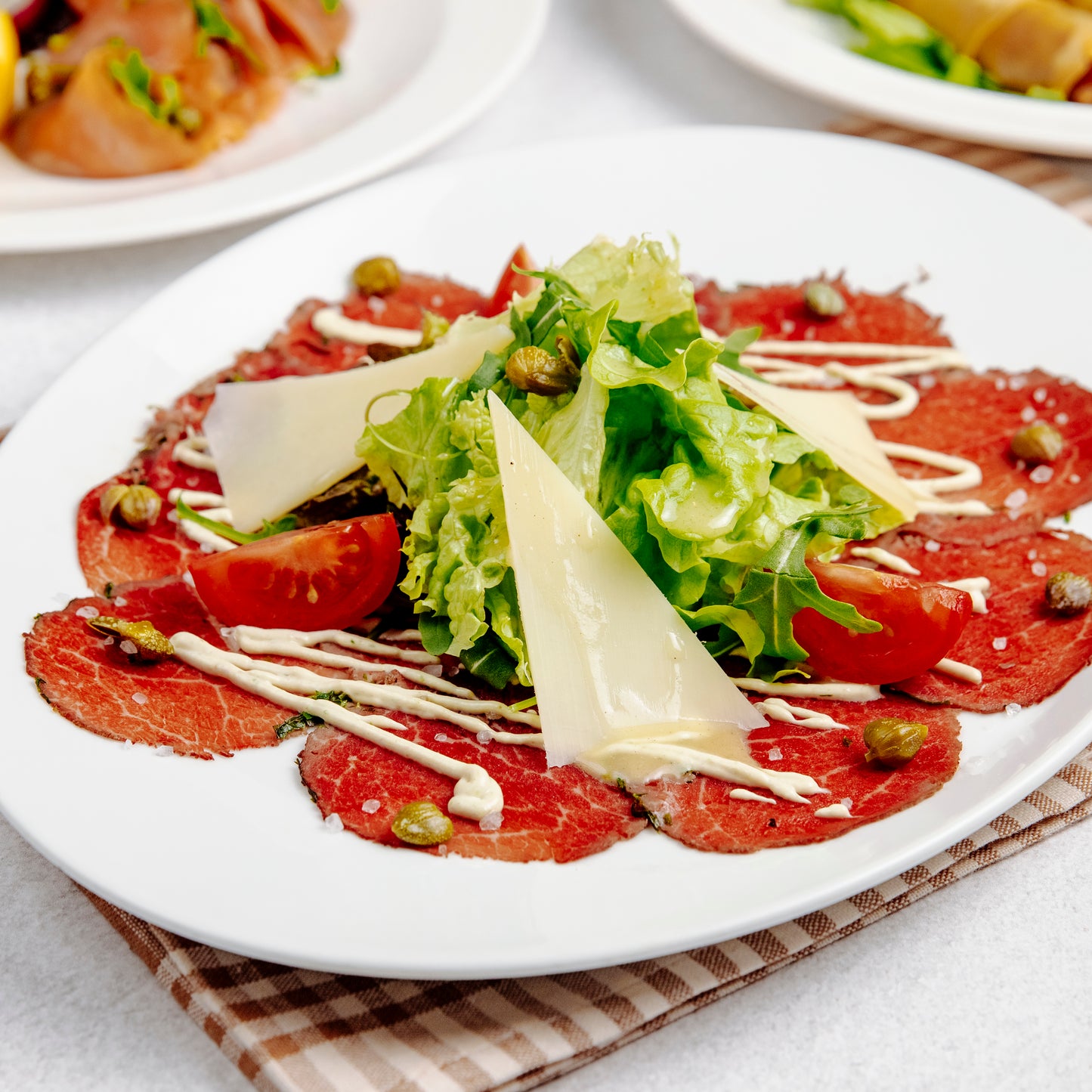 Ossenhaascarpaccio, rucola, tomaat, pijnboompitten en parmezaan