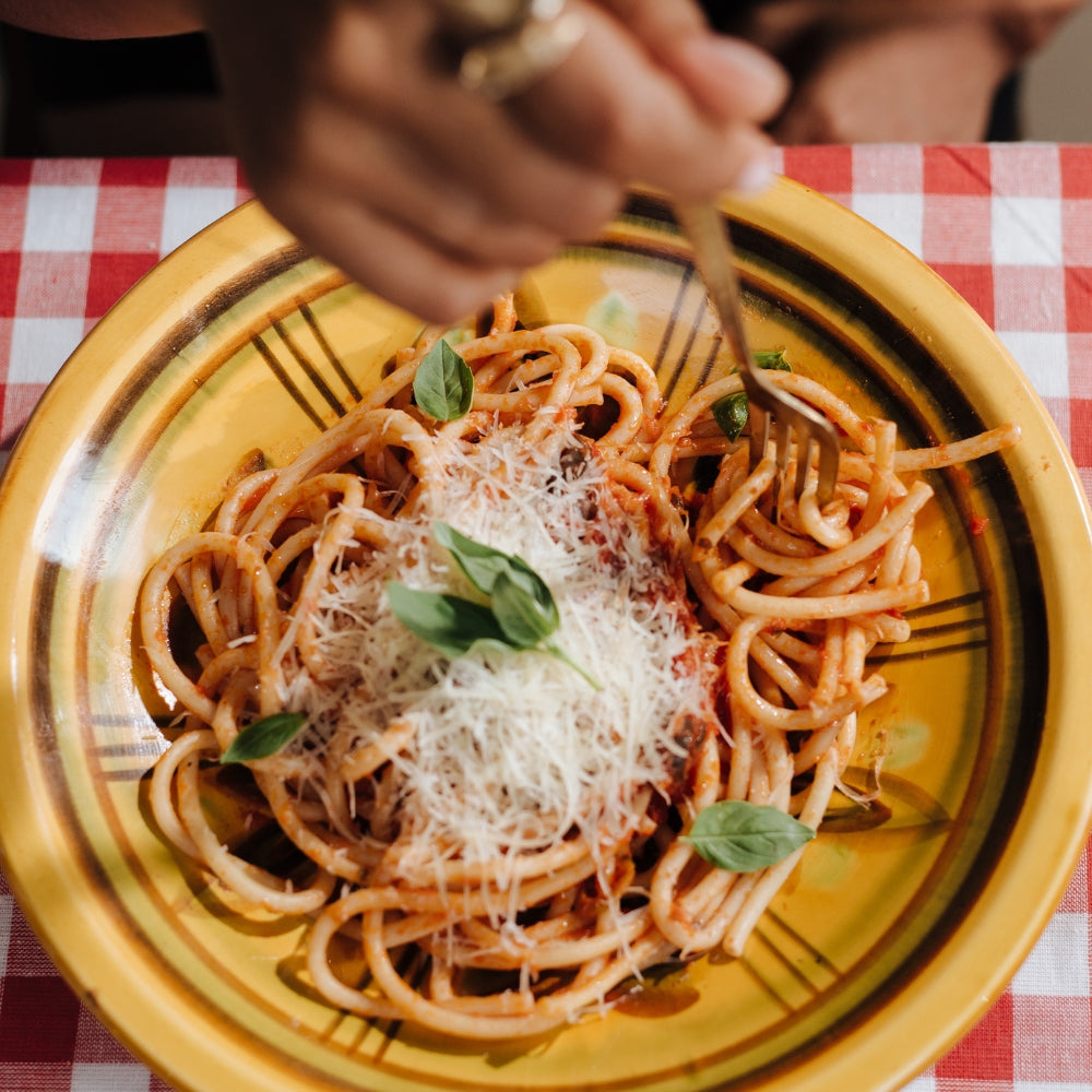 Spaghetti met mozzarella, spekjes, tomaat, pijnboompitten en basilicum